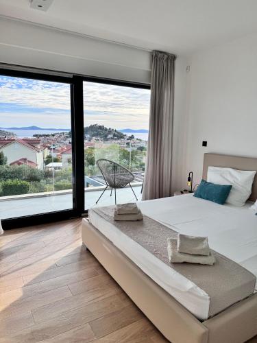 a bedroom with a large bed and a large window at Villa Puro in Tribunj