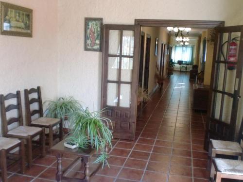 a hallway of a house with chairs and a door at Hotel Restaurante Atalaya in Comares