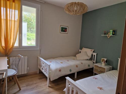 ニヨンにあるLes LUCIOLESのベッド2台と窓のある寝室