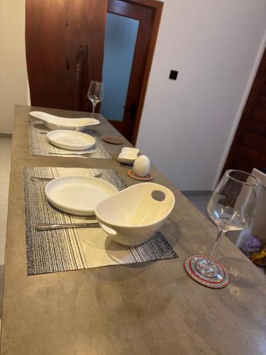 a wooden table with plates and wine glasses on it at Rock Harmony Villa in Hikkaduwa