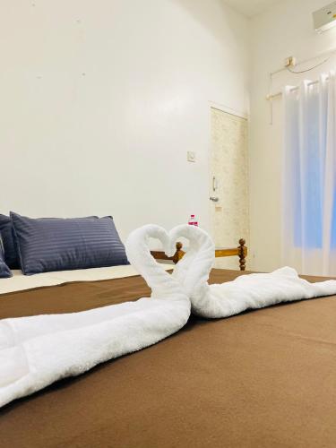 a white swan laying on the floor in a bedroom at Lima Beach House Varkala in Varkala