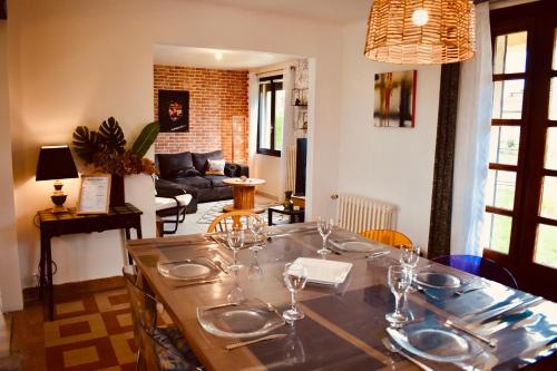 ein Wohnzimmer mit einem Tisch und Weingläsern darauf in der Unterkunft L'AQUARELLE - Escapade normande pour 6 pers in Grugny