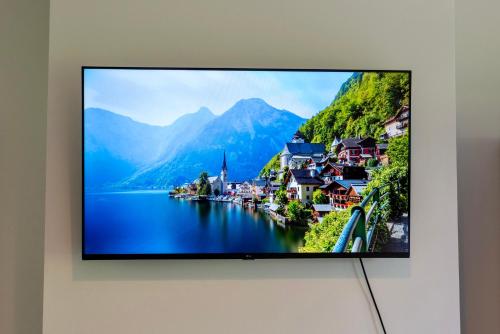 a flat screen tv hanging on a wall at Modern 5 Bed Home, TV in each room, Free BT WiFi & Parking - 62 BW in Solihull