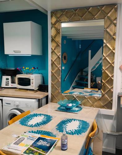 a kitchen with a table and a mirror at Maison de Pêcheur La Gorge Bleue in Saint-Valéry-sur-Somme