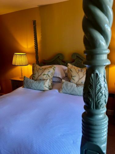 a bedroom with a bed with a green post at The Seagrave Arms in Weston Subedge