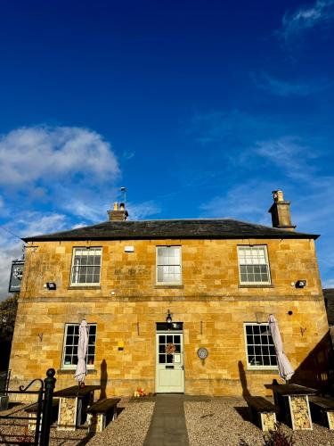 a large brick building with a white door at The Seagrave Arms in Weston Subedge