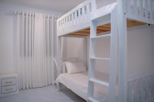 a white bunk bed in a white room with a bed at Cinnamon Wave Villa - Thalaramba, Mirissa in Matara