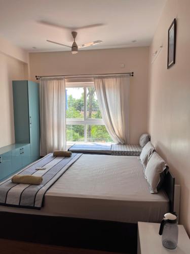 a bedroom with a large bed with a window at Villa19, ECR in Tirupporūr