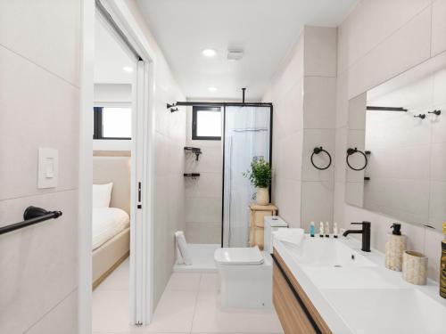 a white bathroom with a shower and a toilet at The Hills Residence in Simpson Bay