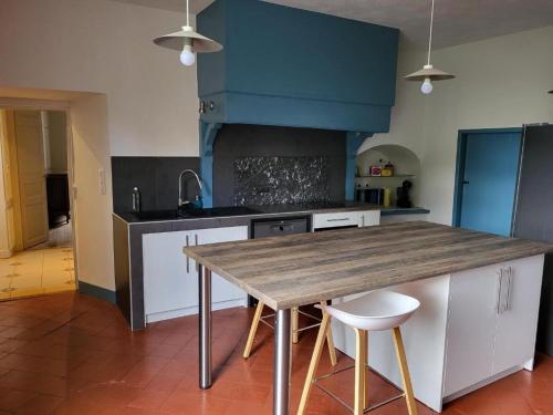 eine Küche mit einem Holztisch mit zwei weißen Stühlen in der Unterkunft Grand Gîte au cœur du village avec jardin in Regny