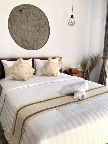 a bedroom with a large bed with white sheets and pillows at Skyland Kintamani in Kubupenlokan