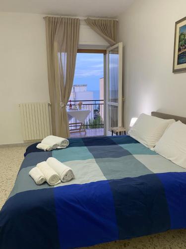 a blue and white bed with two towels on it at Sunset Home in Bari