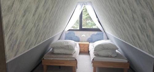 zwei Betten in einem kleinen Zimmer mit Fenster in der Unterkunft A-Frame am Ochsenkopf in Mehlmeisel