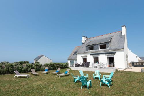 a group of chairs sitting on a lawn in front of a house at Tipoz'immo-Maison de la Baie vue mer accès à pied - jardin clos in Penhors