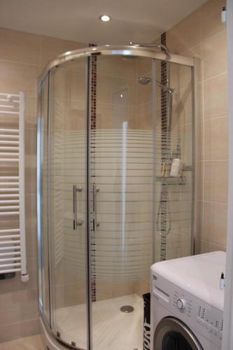 une douche dans une salle de bain avec machine à laver dans l'établissement Fun and quiet, à Paris