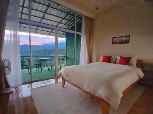 a bedroom with a bed and a large window at ดิ เอสเคป อินทนนท์ - The Escape Inthanon in Ban Yang