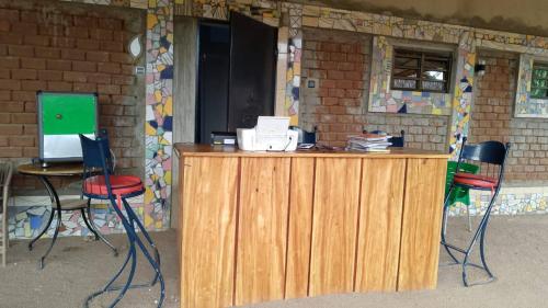 a counter with two chairs and a table with a laptop at Monique CZ Abomey Plage in Abomey