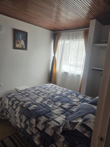 Un dormitorio con una cama y una ventana en Los Muiscas Tunja, en Tunja