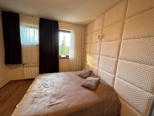 Ένα ή περισσότερα κρεβάτια σε δωμάτιο στο Апартаменты Гранд Ризорт с камином и видом на лес