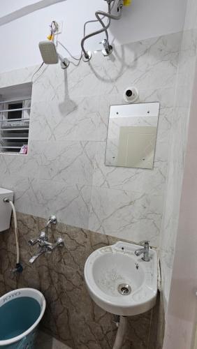 un baño con lavabo y espejo en Guru residency, en Bangalore