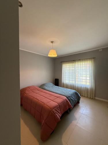 ein Schlafzimmer mit einem Bett mit einer roten Decke und einem Fenster in der Unterkunft Alquiler en Uribelarrea in Uribelarrea