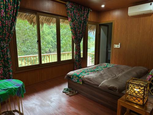 ein Schlafzimmer mit einem Bett und einem großen Fenster in der Unterkunft Cát Lý Camping homestay in Ha Giang