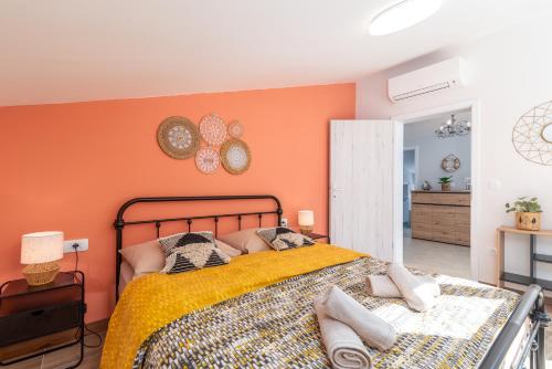 a bedroom with a bed with an orange wall at Villa Cosy in Trogir