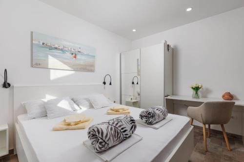 Un dormitorio blanco con una cama con toallas. en Apartments Martina Studio, en Njivice