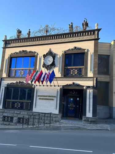 a building with two american flags and a clock on it at Prime Suites Hotel in Yerevan