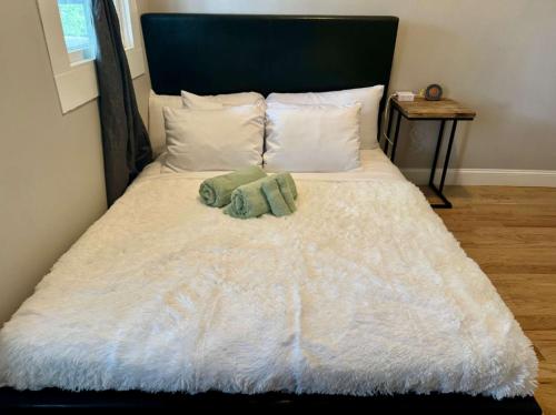 a white bed with two green towels on it at Highland Apartment in Columbus