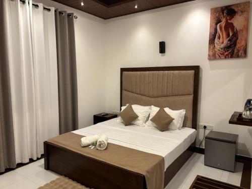a bedroom with a large bed with white sheets and pillows at Knuckles View Hotel in Palapatwela