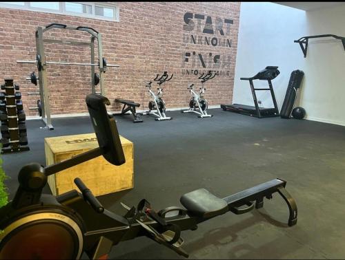 a gym with several exercise bikes and a brick wall at modern apartment excellent location coquimbo in Coquimbo