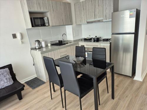 a kitchen with a table and chairs and a refrigerator at modern apartment excellent location coquimbo in Coquimbo