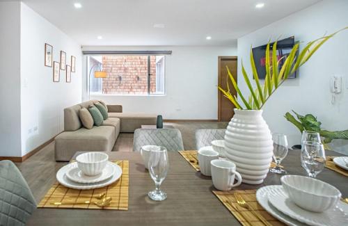 a dining room with a table with a vase on it at The Andes apartment Patio & Luxury in Cuenca