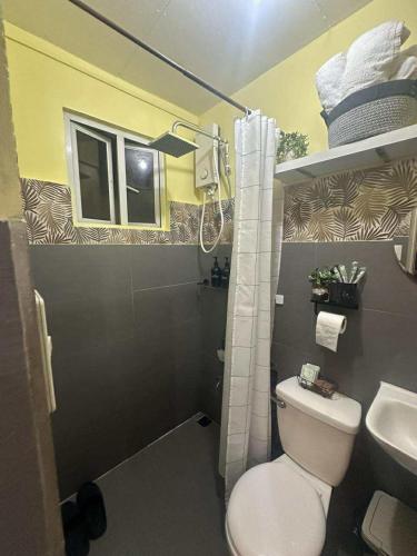 a bathroom with a white toilet and a sink at MisyEdz Homes Clark Dau in Mabalacat