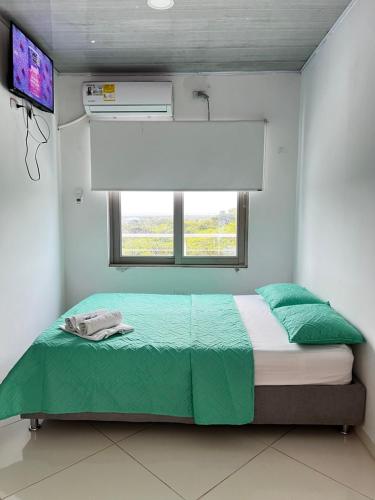 a bedroom with a bed with a window and avertisement at Hotel mirador Dubai in San Antero