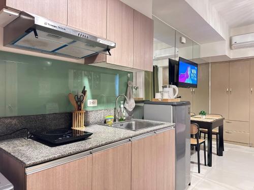 Cozy Studio Unit - Inspiria Condominium Beside Abreeza Mall في مدينة دافاو: مطبخ مع حوض وطاولة عمل