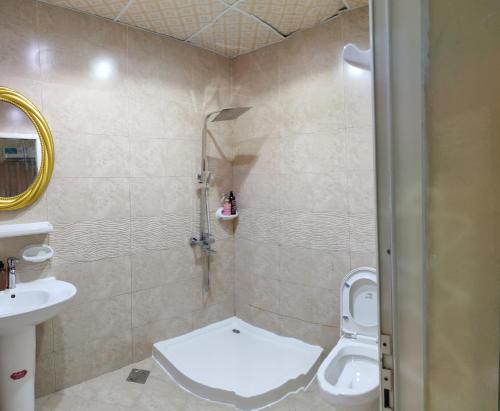 a bathroom with a shower and a toilet and a sink at Patio Boy Dean Guesthouse in Fujairah