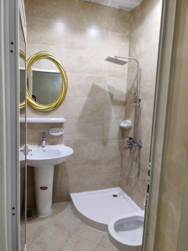 a bathroom with a sink and a toilet and a mirror at Patio Boy Dean Guesthouse in Fujairah