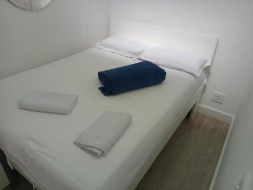 a white bed with a blue pillow on it at 1 on albert Luxury apartment in Cape Town