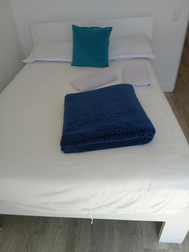 a white bed with a blue blanket on it at 1 on albert Luxury apartment in Cape Town