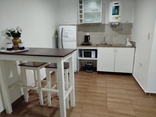 a kitchen with a wooden table and a kitchen with white cabinets at EDIFICIO REY NIÑO in Posadas