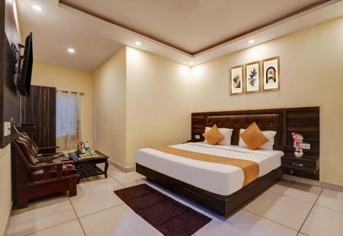 a bedroom with a large bed and a chair at Hotel City Lite Near Delhi International Airport in New Delhi