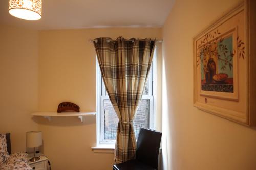 - une fenêtre avec un rideau dans la chambre dans l'établissement Three Bedrooms Flat in Central Edinburgh Old Town , Grassmarket Heart of Edinburgh Flat Sleeps 6 , EH1 58 Grassmarket, Edinburgh, à Édimbourg