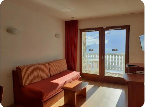 een woonkamer met een bank en een balkon bij Hourquette in Bagnères-de-Bigorre