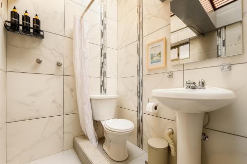 een badkamer met toilet en wastafel bij Panoramic Loft Unique Windows and Views in Cuenca