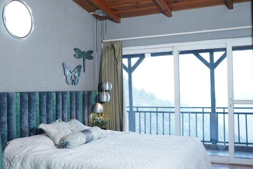 a bedroom with a bed and a large window at 2Bhk Home By Da Alohas Mukhteshwar in Mukteswar