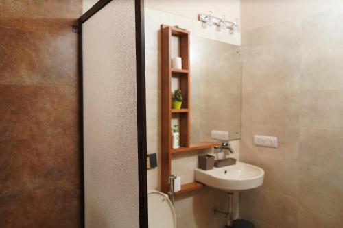 a bathroom with a sink and a toilet and a mirror at 2Bhk Home By Da Alohas Mukhteshwar in Mukteswar