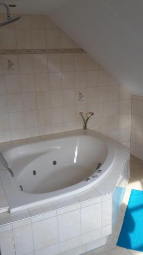 a white bath tub with a vase of flowers in it at ZeitVergessen in Krummhörn