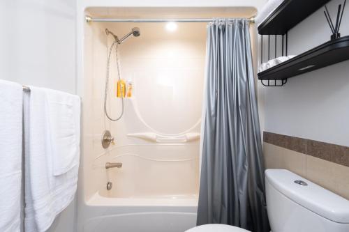 Un baño con cortina de ducha y un inodoro. en Stylish Scenic Oasis 2-Bedroom Suite West Van, en West Vancouver